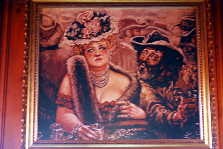 Painting of a cowboy and dressed up lady in a western saloon on display at the Winchester Cafe